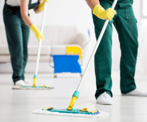 Cleaning team wiping the floor using mops in the flat Cleaning team wiping the floor using mops in the flat